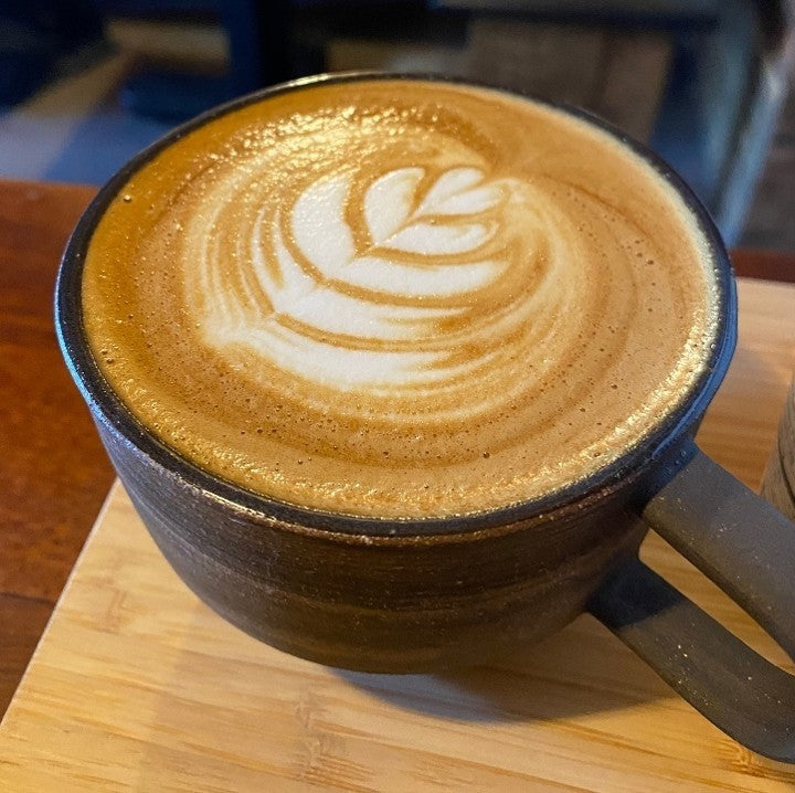 Expertly crafted latte art at Snowy Owl Coffee's Cape Cod cafes, featuring house-roasted espresso and velvety steamed milk, served in our signature ceramic mug at our Brewster, Chatham, and Sandwich locations.
