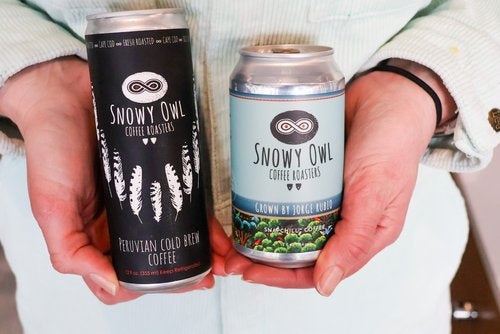 A can of Snowy Owl cold brew coffee held next to a can of Snowy Owl snapchill coffee